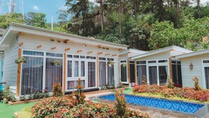 Um edifício de dois andares com grandes janelas e uma piscina.