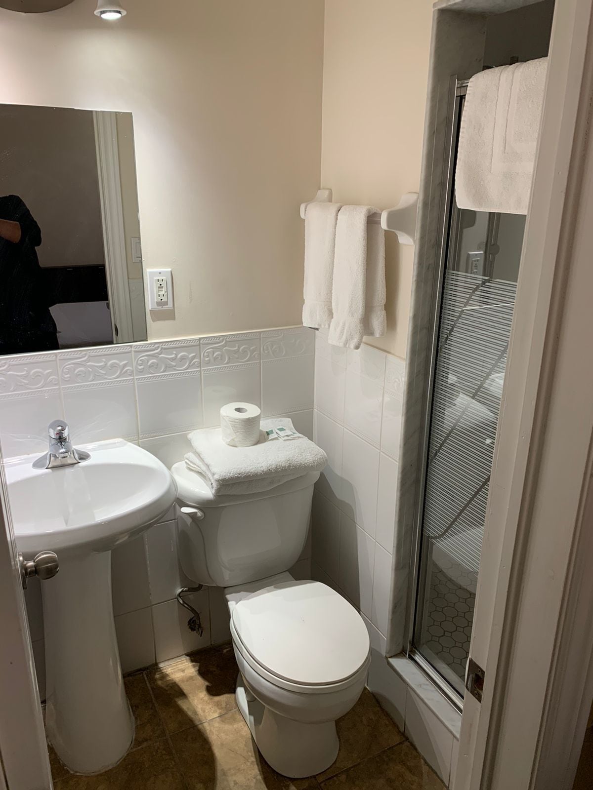 A bathroom with a sink, toilet, and shower area.