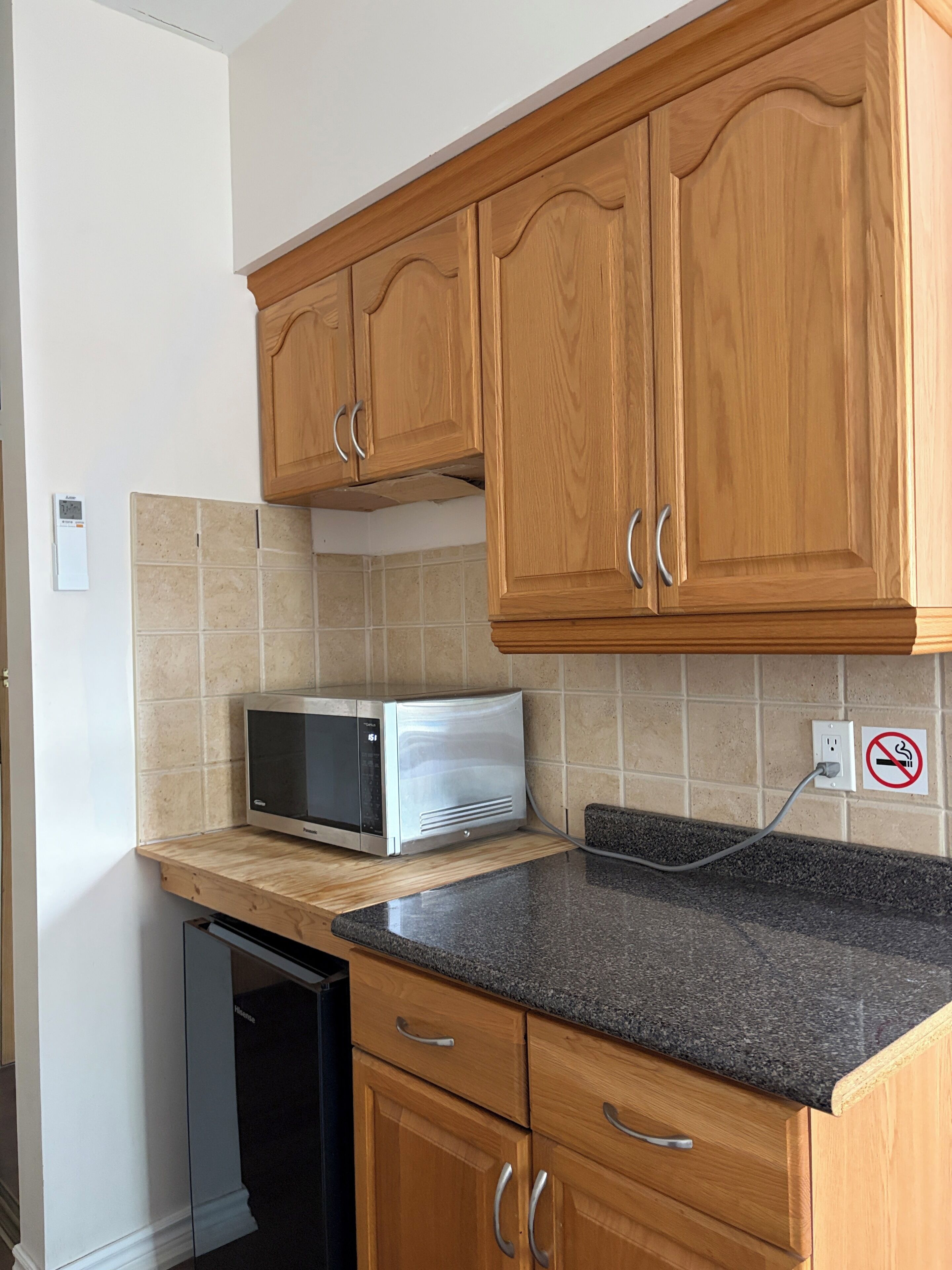 A kitchen with wooden cabinets, a microwave, and a dishwasher.