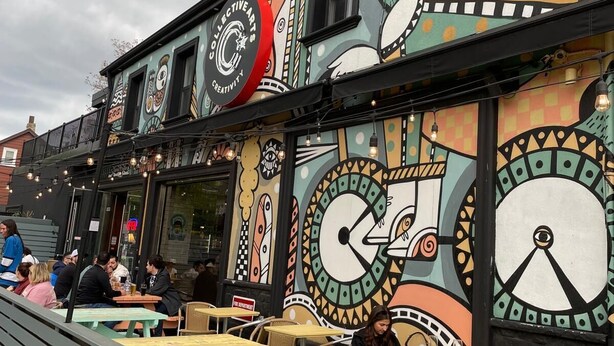 A building with colorful murals and outdoor seating.