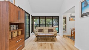 A modern living room with a wooden bookshelf, a beige sofa, and a coffee table.
