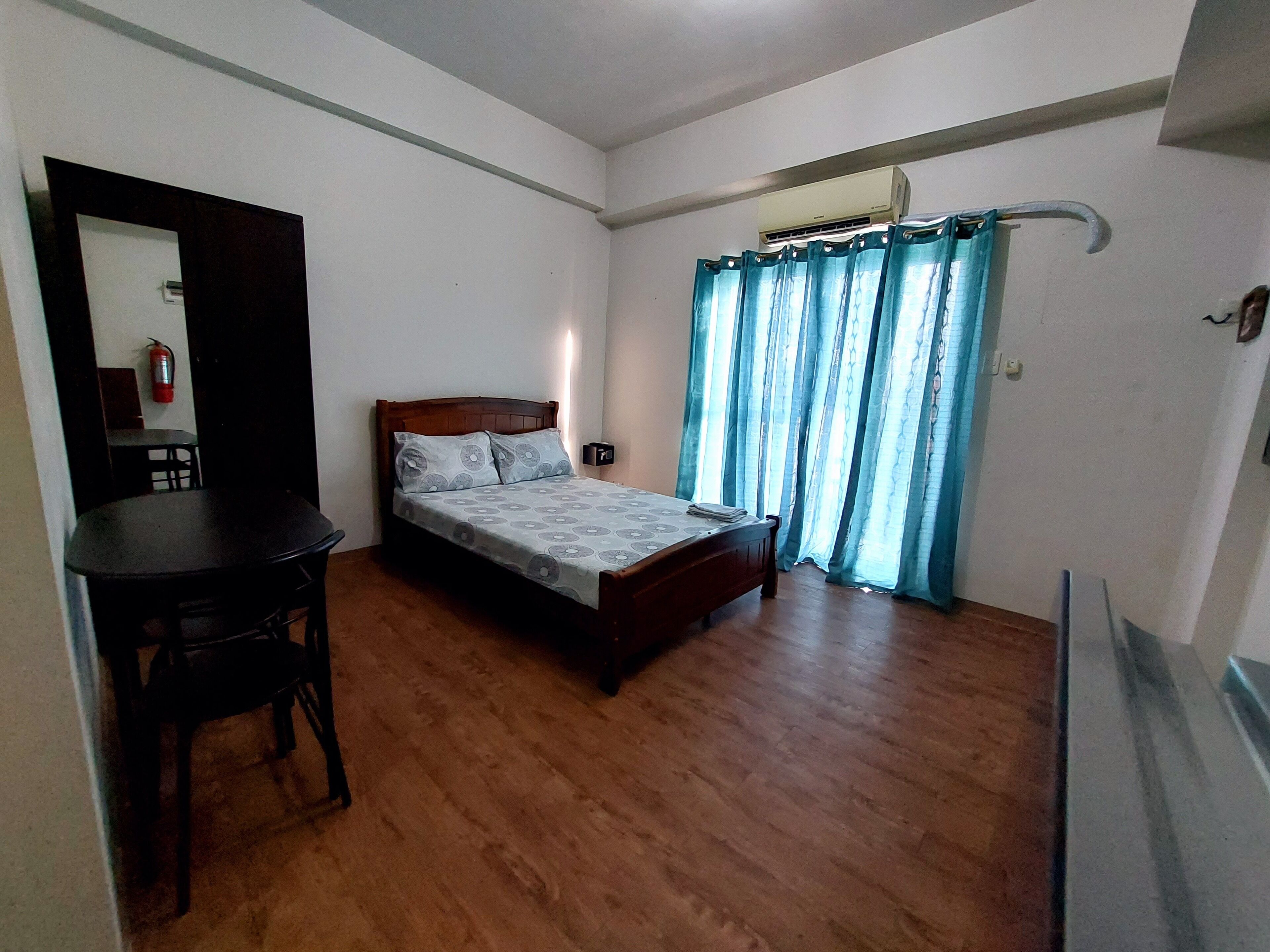 A bedroom with a wooden bed, a desk, and a chair.