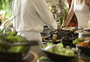 A chef preparing food in a kitchen with various dishes and cooking utensils. - Original Sokos Hotel Kupittaa (Turku)