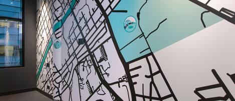 A wall with a stylized map design, including a circular emblem and a section with a blue background.