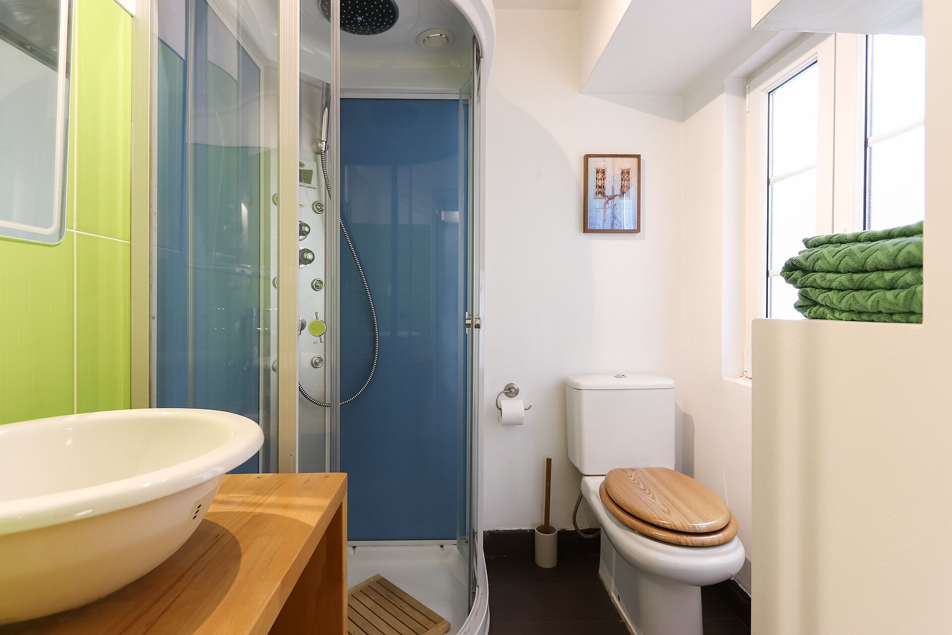 Un baño pequeño con ducha, inodoro y lavamanos.
