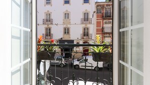 A balcony with wrought iron railings and potted plants. - Cozy & Stylish central apt in XIX century building (Lisboa)