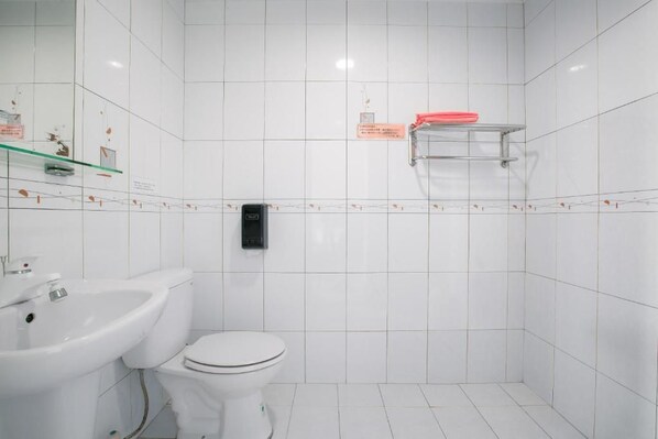 A bathroom with white tiles, a white toilet, a sink, and a soap dispenser. - Long Beach Private Lodging (Magong)