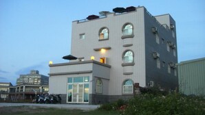 Een meerlaags gebouw met een plat dak, grote ramen en een hekwerk.
