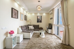 Appartamento, 1 camera da letto, balcone, vista mare | Area soggiorno | TV a schermo piatto