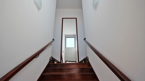 A wooden staircase with a handrail, leading to a door at the top. - Lazareto Apartment (Funchal)