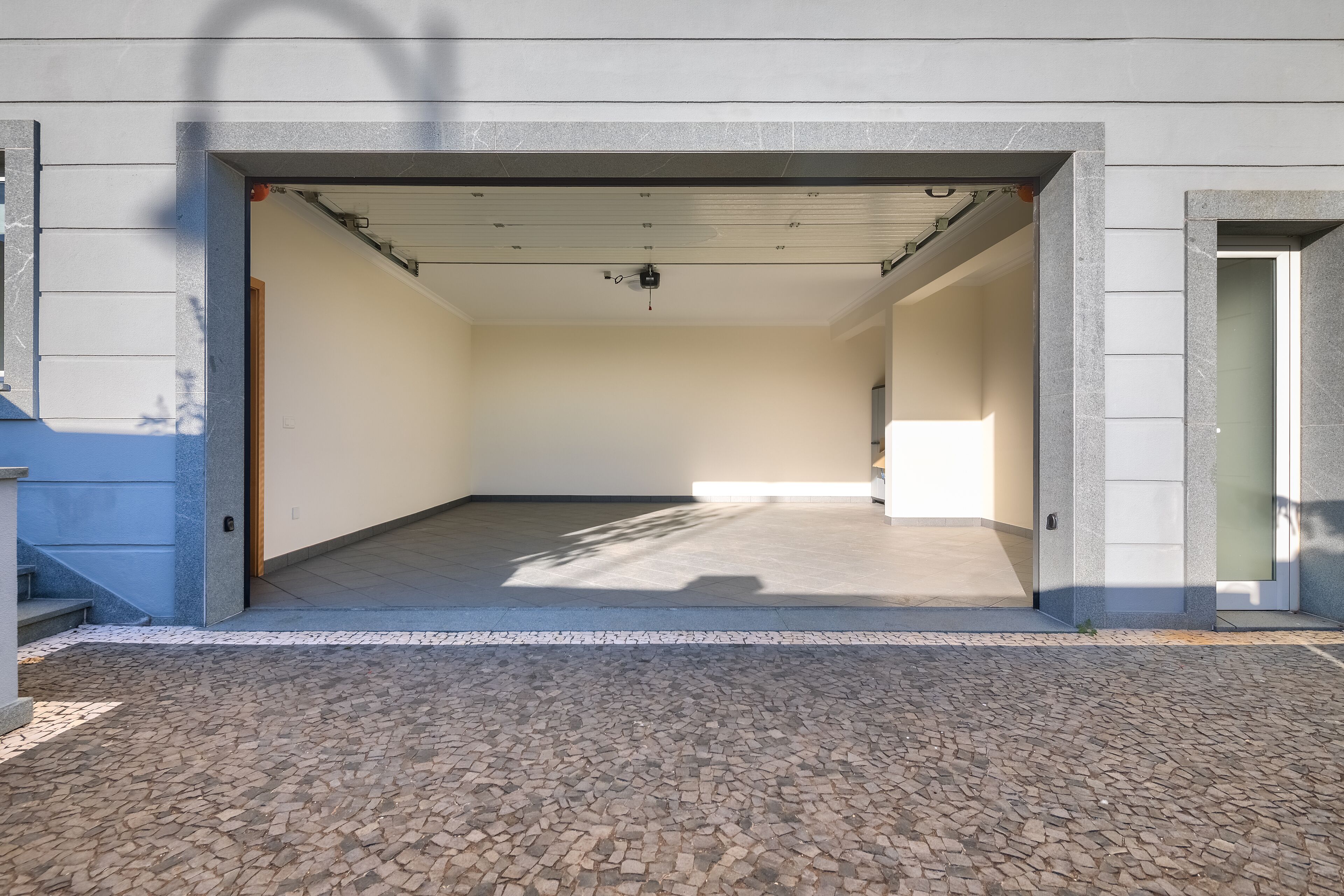 Un garage capiente con pavimento in cemento e soffitto a vista.