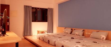 Un dormitorio con cama, escritorio y ventana con cortinas.