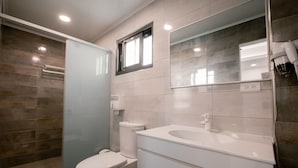 A modern bathroom with a toilet, sink, and shower area. - Polaris B&B (Magong)