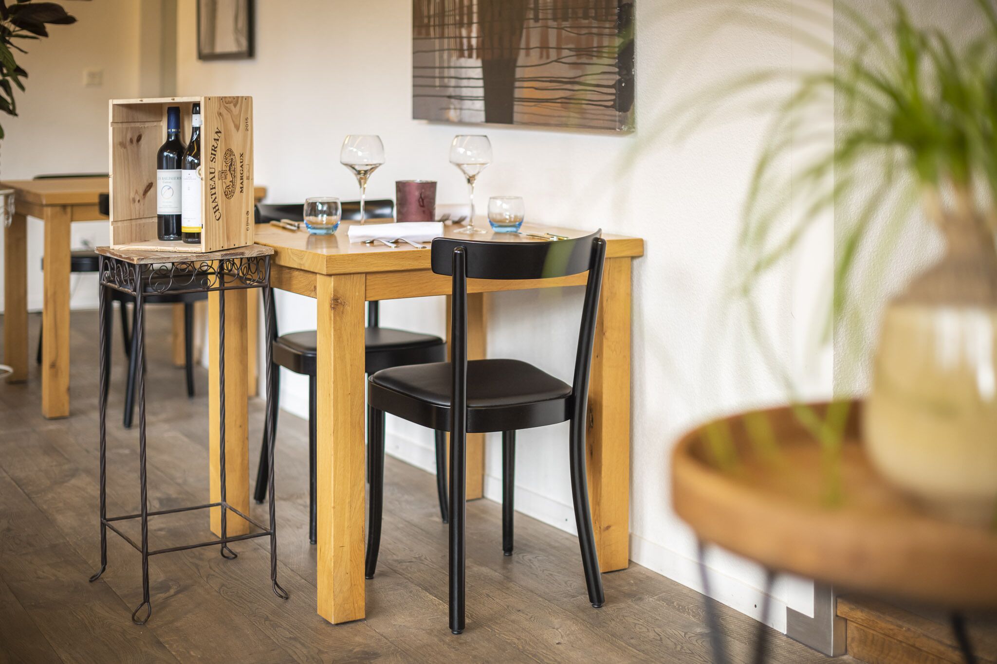 Ein Essbereich mit Holztisch, schwarzen Stühlen und einem Weinkühlschrank mit Flaschen.
