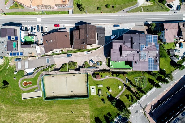 Vista aérea de um complexo com vários edifícios, áreas de estacionamento e zonas verdes.