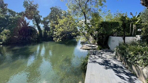A wooden dock extending over a calm river, surrounded by lush greenery and trees. - Villa Louise-Rose (Villeneuve-Loubet)