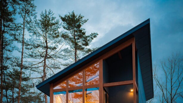 A modern two-story house with large windows, a dark exterior, and a wooden door. - Black Crane Chalet (Hakuba)