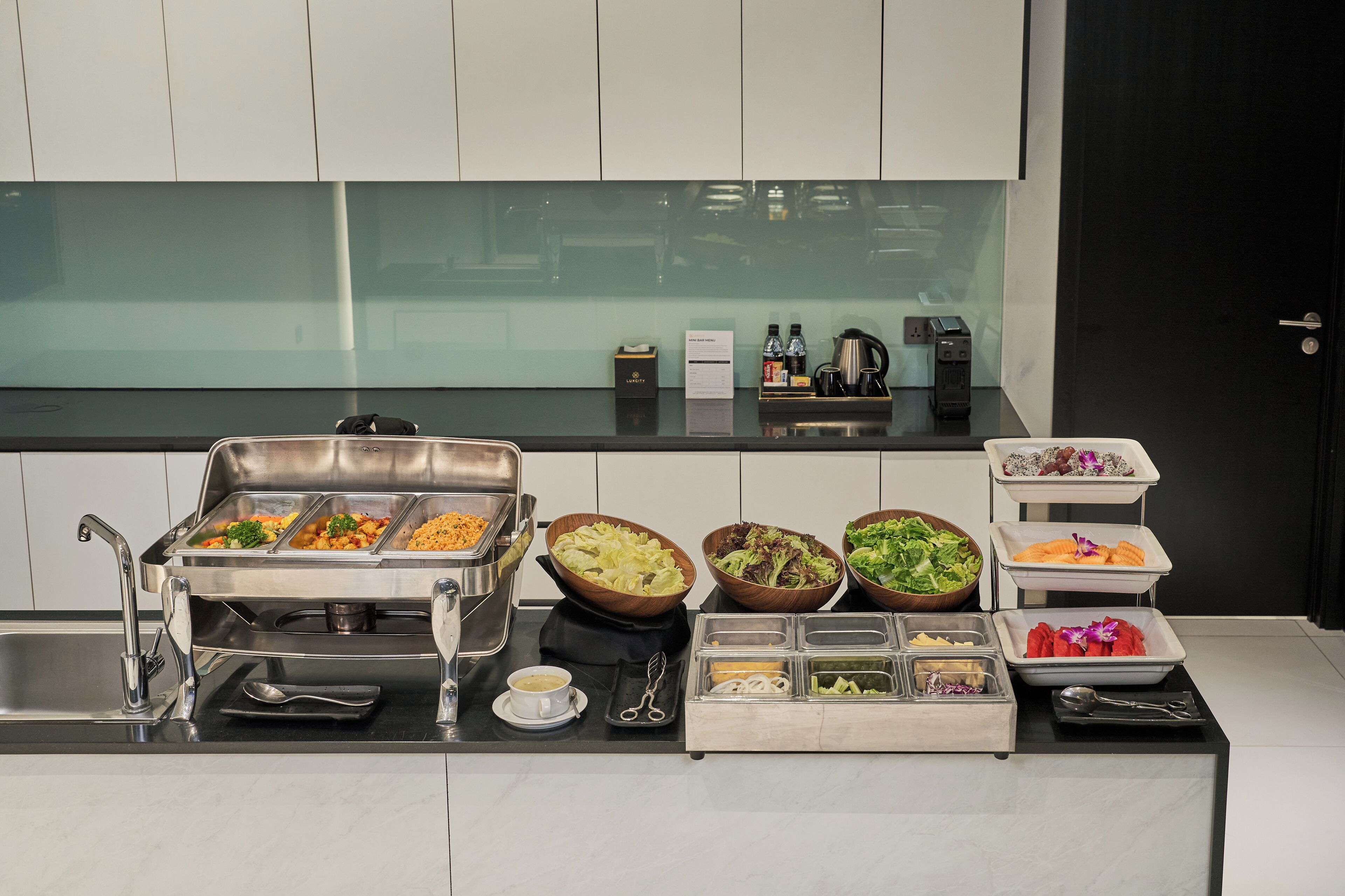 A buffet setup with various food items and utensils.