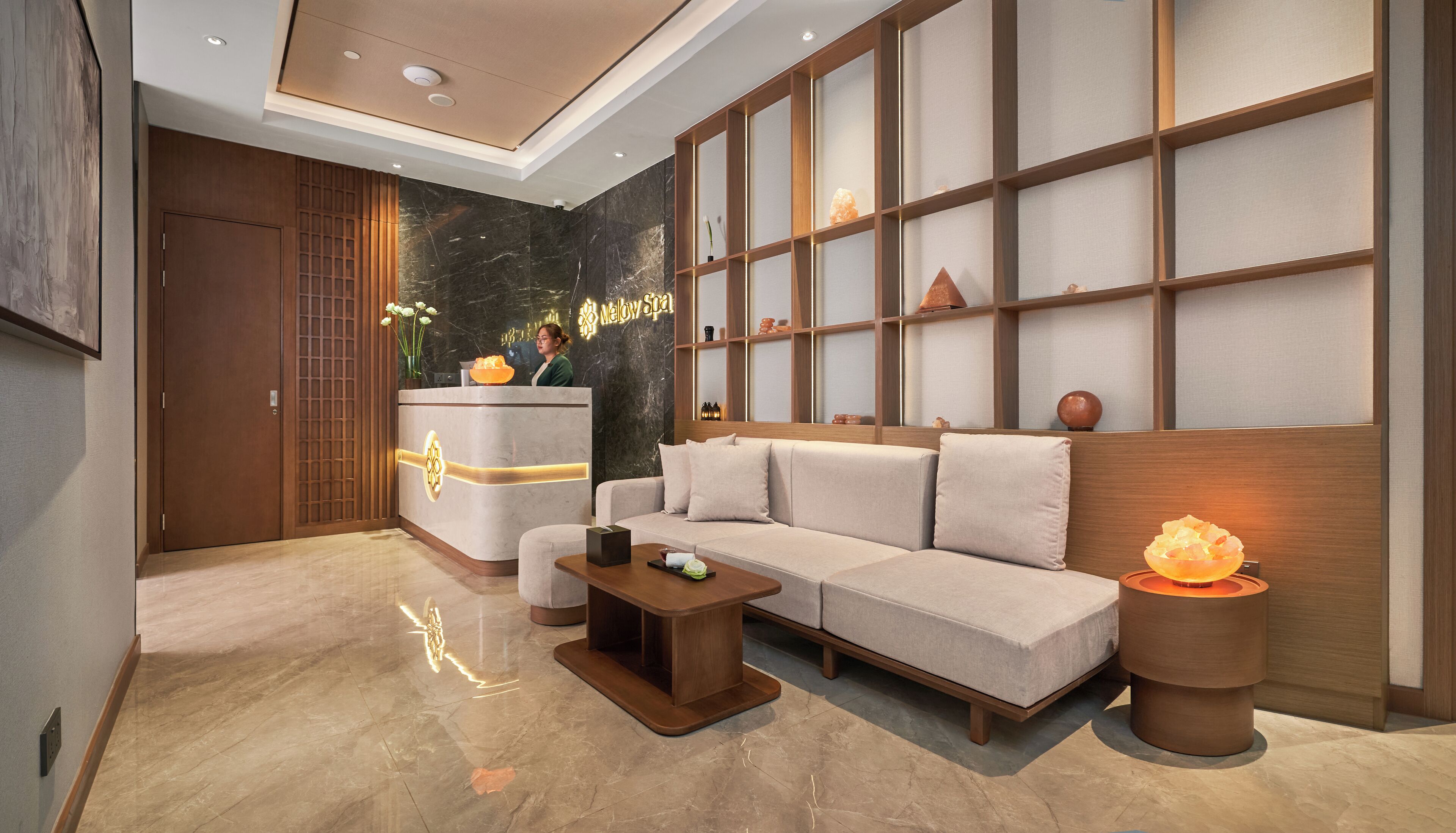Ein moderner Spa-Bereich mit Rezeption, einer Sitzecke und einer Massageliege.