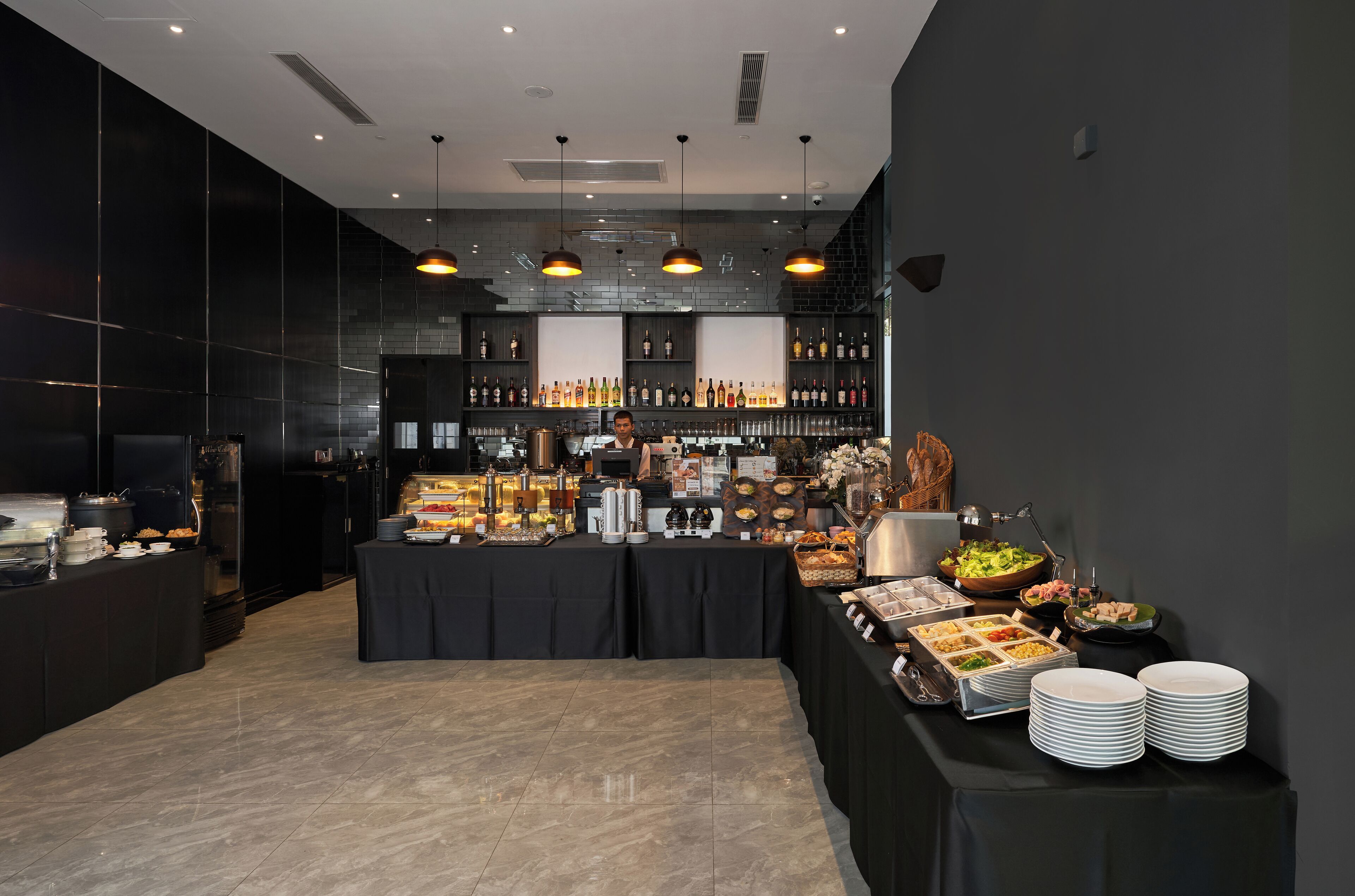 A modern buffet setup with a variety of food and drink options, including a wine selection and a buffet table with multiple dishes.