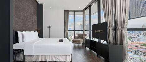 A modern hotel room with a large bed, a TV, and a city view.
