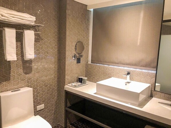 A modern bathroom with a rectangular sink, a toilet, and a shower area.