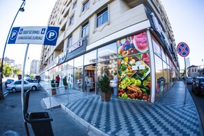A market building with a large glass storefront displaying fresh produce.