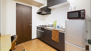 Cocina compacta con estufa, fregadero y microondas.
