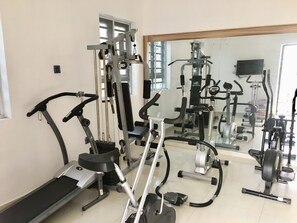 A gym with various exercise equipment including treadmills, stationary bikes, and weight machines. - Sky Rock Hotels (Lagos)