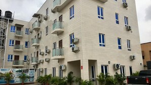 A multi-story building with balconies, air conditioning units, and potted plants. - Sky Rock Hotels (Lagos)
