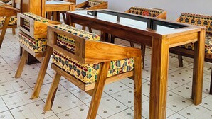 Un restaurante con mobiliario de madera y techo de paja.