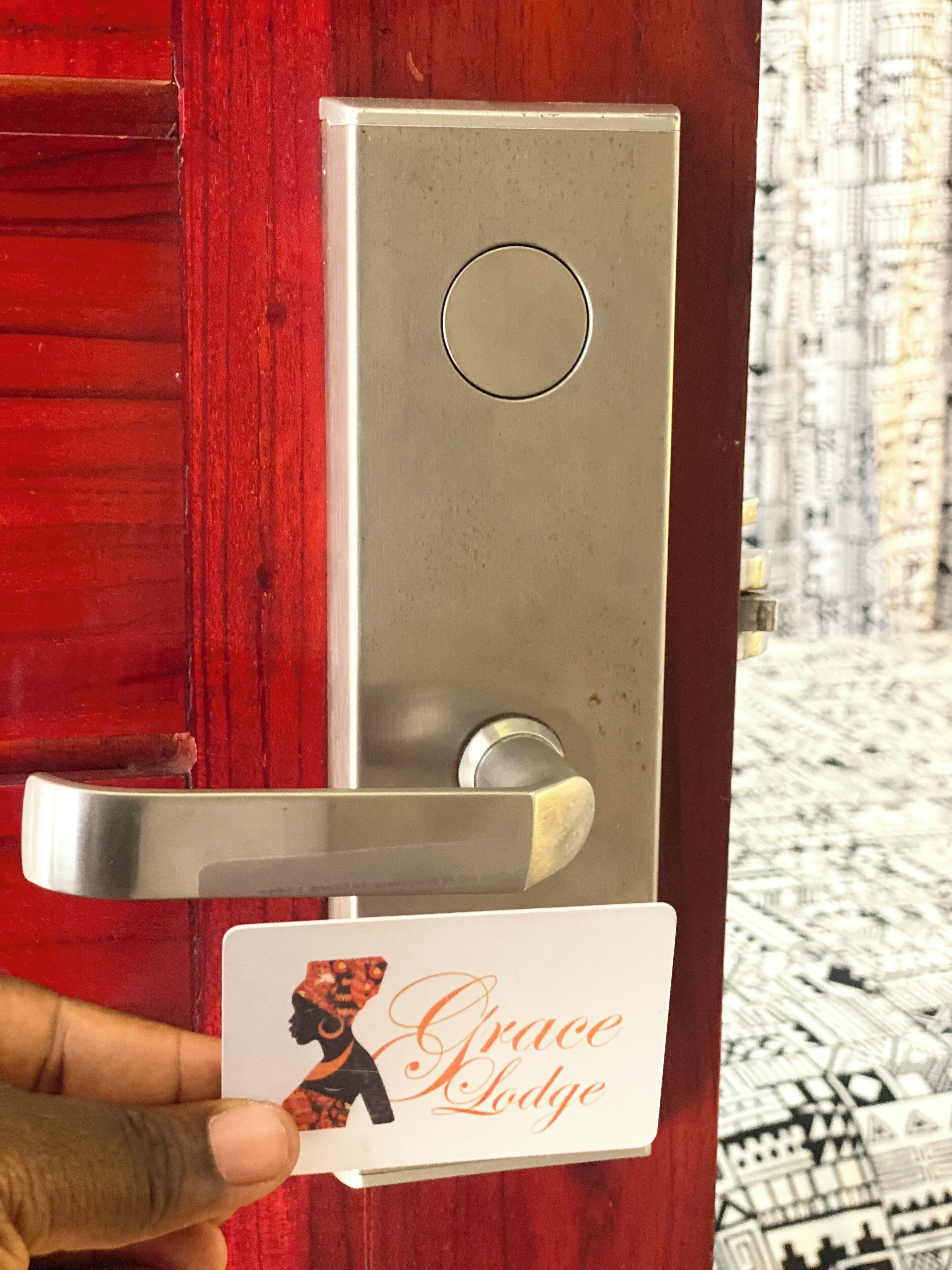Una puerta con un picaporte metálico y una tarjeta con un logotipo y texto.