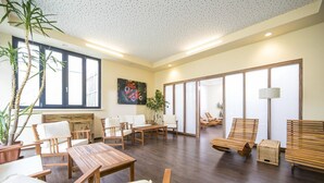 A spacious room with wooden furniture, large windows, and a painting on the wall.