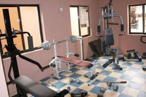 A gym with various exercise equipment, a checkered floor, and windows. - Roban Hotel Enugu (Enugu)