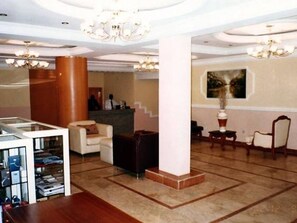 A lobby with a reception desk, seating area, and a staircase. - Roban Hotel Enugu (Enugu)