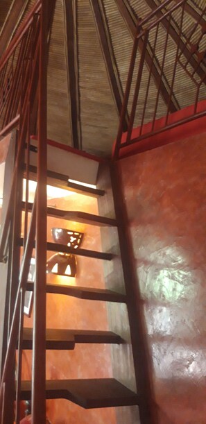 A staircase with metal railings and a red wall. - Auberge Le Dakan (Mbour)