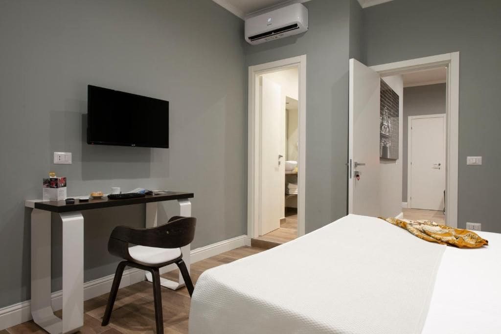 Een slaapkamer met een bed, een bureau, een stoel en een televisie.