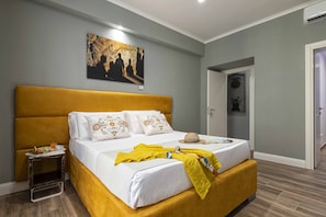 A bedroom with a large bed, a bedside table with a tray of breakfast, and a painting on the wall. - Dante Maison De Prestige (Naples)