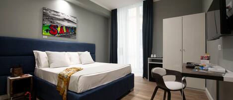 Un dormitorio moderno con una cama grande, un escritorio y un armario.