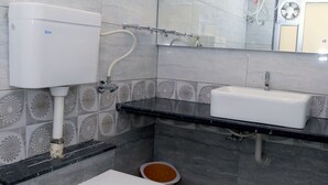 Une salle de bain moderne équipée de toilettes, d’un lavabo et d’une douche.