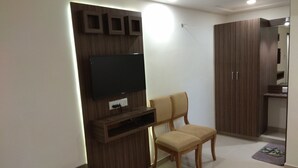 Un salon moderne avec un téléviseur à écran plat fixé à un mur en bois, une chaise en bois et une armoire.