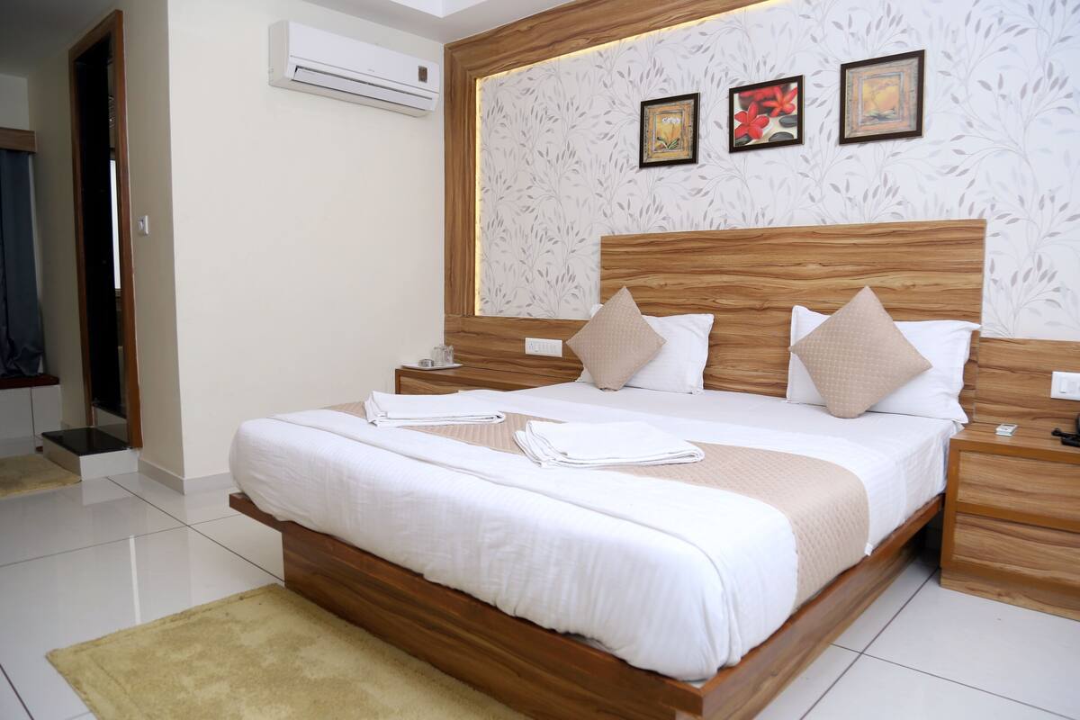 A neatly made bed with white linens, a wooden headboard, and two bedside tables.