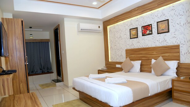 Une chambre d’hôtel moderne avec un lit en bois, un téléviseur à écran plat et une grande fenêtre.