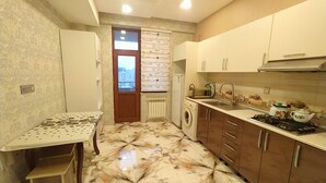 A compact kitchen with a washing machine, a sink, and a stove.