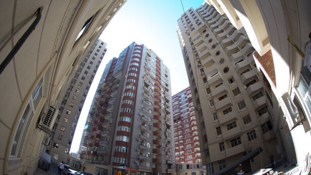 A high-rise building with multiple floors, large windows, and balconies.