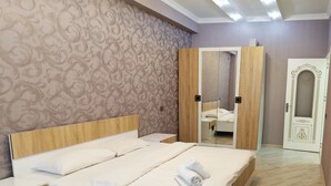 A bedroom with a large bed, wooden wardrobe, and a mirror cabinet. - Bakuvi Tourist Apartment B056 (Baku)