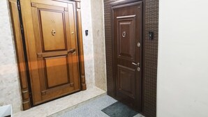 A hallway with two wooden doors, one with a number '55' and another with a lock. - Bakuvi Tourist Apartment B056 (Baku)
