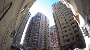 A high-rise building with multiple floors, large windows, and balconies.