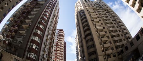 A high-rise building with multiple balconies and a clear sky.