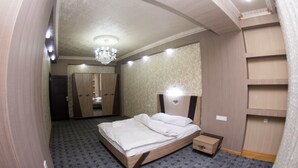 Une chambre à coucher avec un lit, une table de chevet, une commode et un miroir.